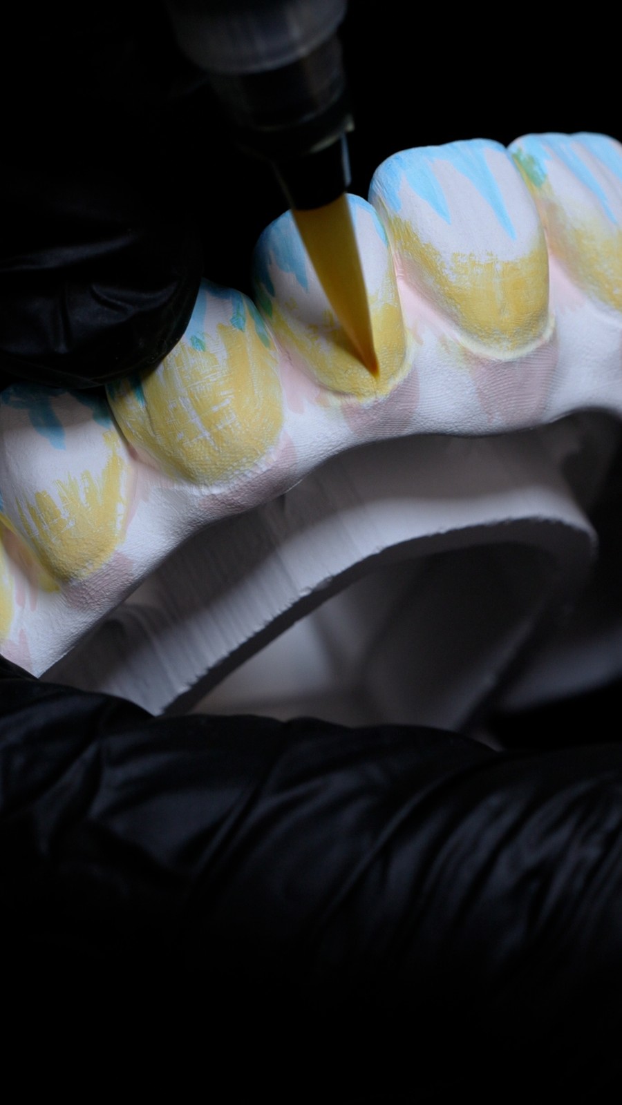 A dental restoration being shaded in our in-house lab