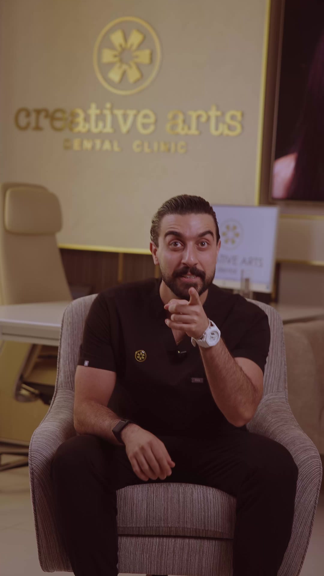 د. سومر دحدل جالس في استقبال كرييتف آرتس ثم يعمل على كرسي العلاج بنظارات التكبير