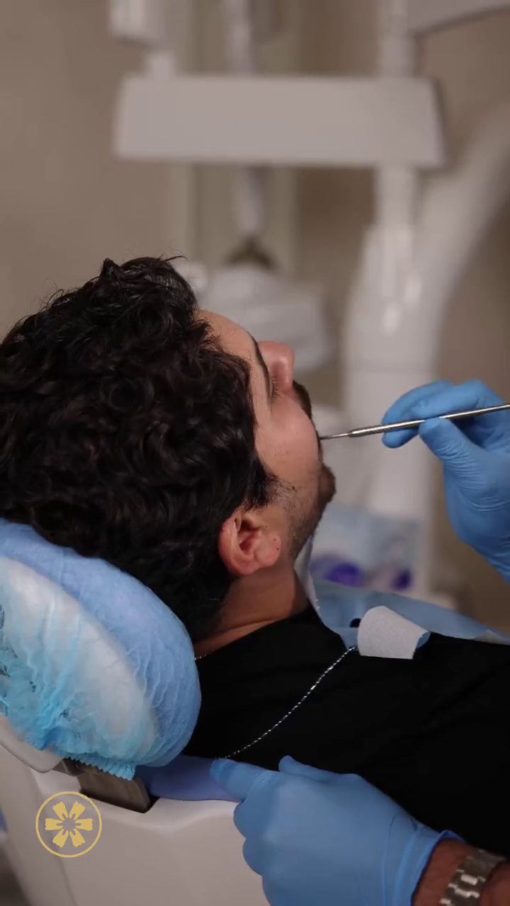 مريض مستلقٍ على كرسي العلاج أثناء فحص تقويم الأسنان