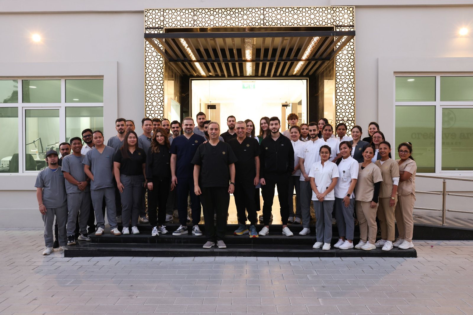 Creative Arts clinic and dental lab team standing together at the building entrance on Jumeira St, Dubai